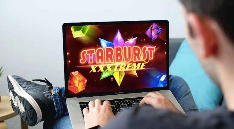pria memainkan xxxtreme starburst baru di laptopnya